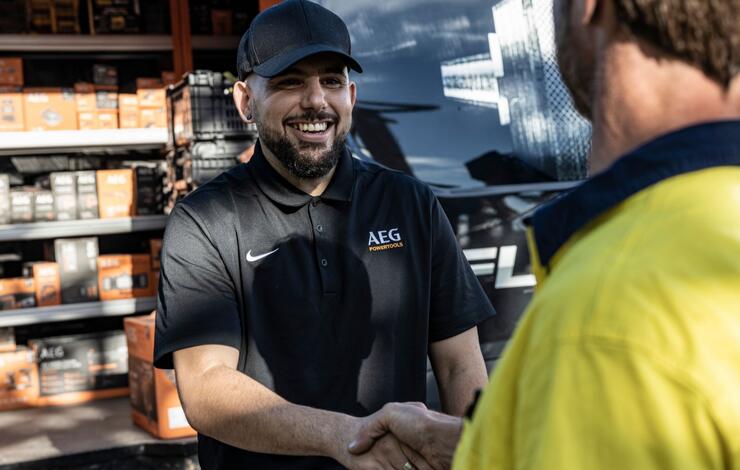 An AEG onsite rep shakes hands with a satisfied customer
